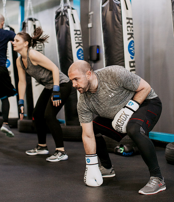 man wearing boxing gloves squatting 