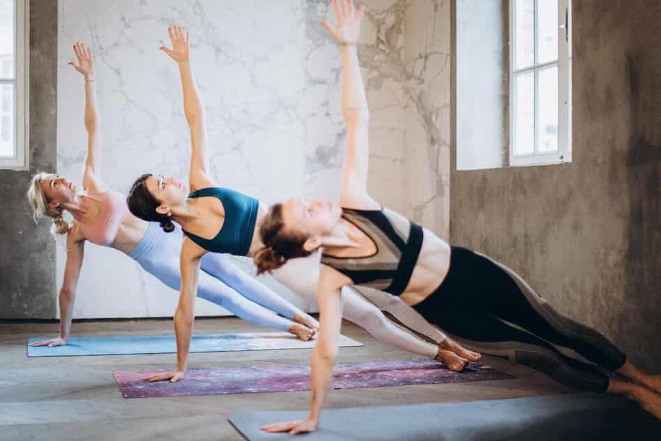 Three women perform a side plank